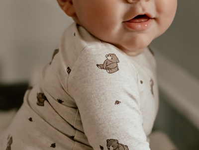 Baby iført That\'s Mine bodystocking i alpaca star med print af bier og bjørne