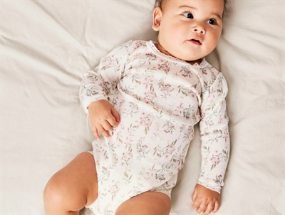 Baby iført Name It body i snow white flowers med blomsterprint