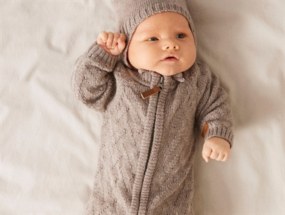 Baby klædt i Name It strikdragt i gråbrun nuance med kabelstrik