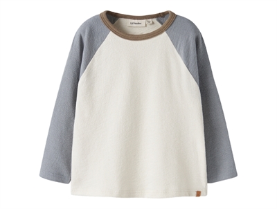 Lil' Atelier bluse i råhvid nuance med blå raglanærmer set forfra