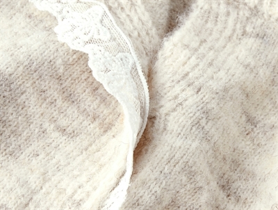 Detalje af blondekant på Name It baby cardigan i peyote melange