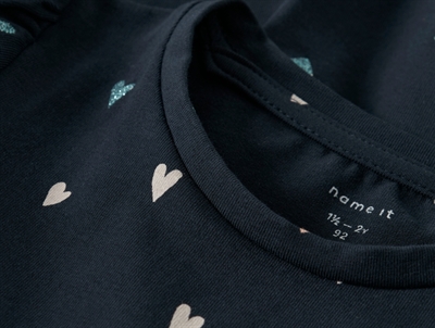 Nærbillede af halsudskæring og hjerteprint på Name It kjole i dark sapphire