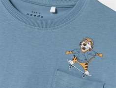 nærbillede af tiger med skateboard og hættetrøje på blå t-shirt fra name it