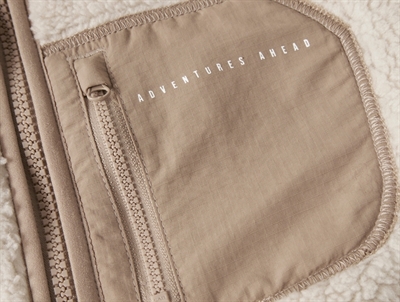 Detalje af brystlomme med tekst Adventures Ahead på Name It teddy jakke