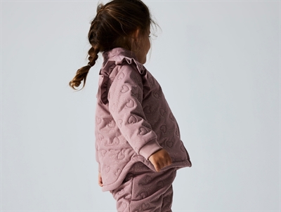 Barn iført rosa Name It termosæt med hjertequilt og flæser