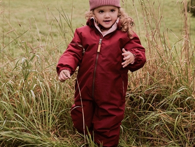 Lil' Atelier flyverdragt i rød red dahlia med fleecefor set på barn i natur