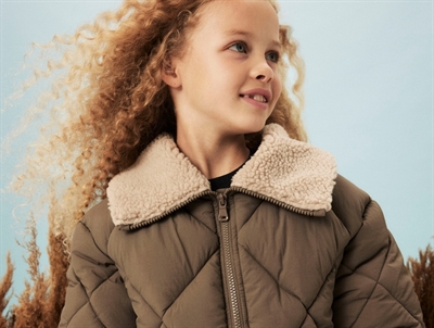 Pige iført brun Name It pufferjakke med teddykrave