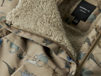 Foerdetalje på Name It flyverdragt silver mink med dinosaurprint