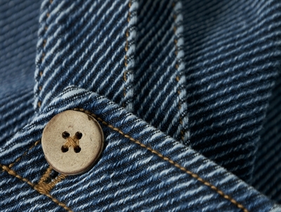 Detalje af knap og syninger på Lil\' Atelier denim overalls i blå