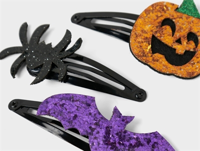 Nærbillede af Name It hårspænde med lilla flagermus, sort edderkop og orange græskar