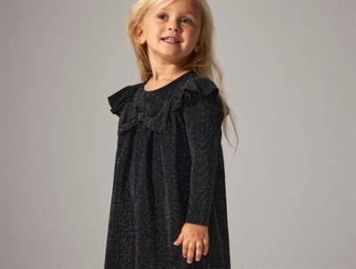 Pige i sort glimmerkjole fra Name It med sløjfedetalje