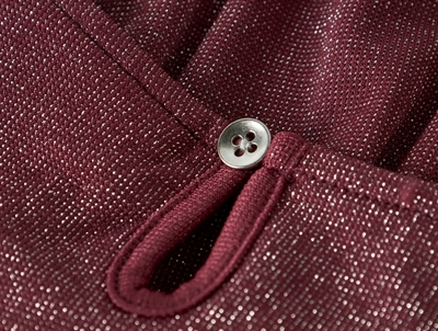 Detalje af knaplukning og glimmer på burgundy Name It kjole