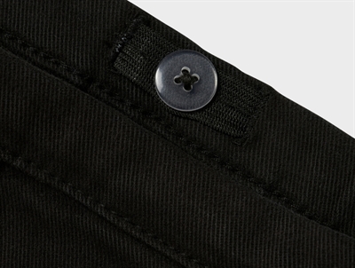 Detalje af knap og linning på Name It sort twillnederdel