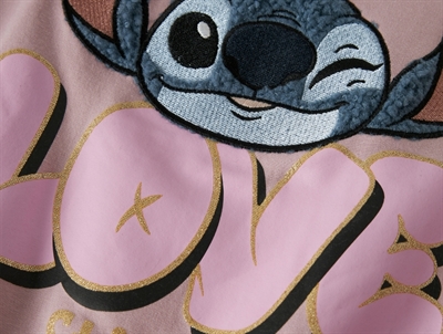Close-up af Stitch og LOVE glimmerprint på sweatshirt soft pink