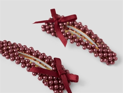 Detaljebillede af hårspænder i bordeaux fra Name It med perler og sløjfe