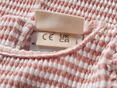 Lil\' Atelier UV dragt i rosa nuance med flæsedetalje