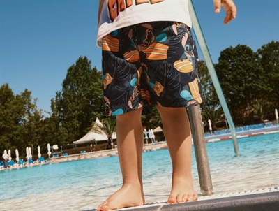 Dreng iklædt Name It Stitch badeshorts navy med allover print