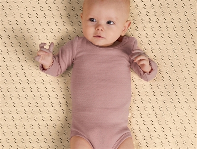 Barn iklædt Lil' Atelier body i rosa nuance med hulmønster