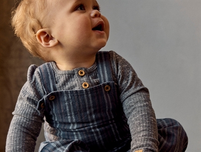 Barn iklædt Name It overall i blå nuance med knaplukning på stropper