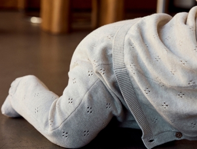 Barn iklædt Name It strikbukser i beige nuance med hulmønster