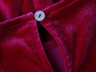 Detalje af knaplukning og velouroverflade på rød kjole fra Name It