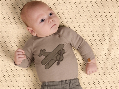 Baby iklædt Lil' Atelier body i beige nuance med fly print