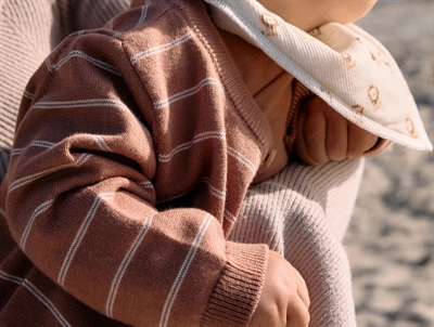 Baby iklædt Name It strikcardigan detalje med label og ribkant