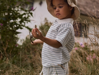Dreng iklædt Lil' Atelier polo t shirt i raahvid nuance med stribet moenster