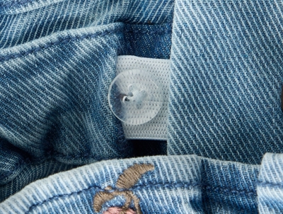 Detalje af justerbar knaphulselastik og denim på Lil\' Atelier jeans til børn