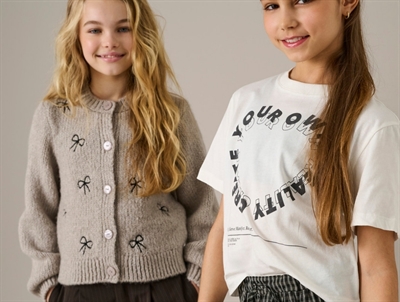 Pige iklædt KIDS ONLY cardigan pumice stone med sløjfedetaljer til piger