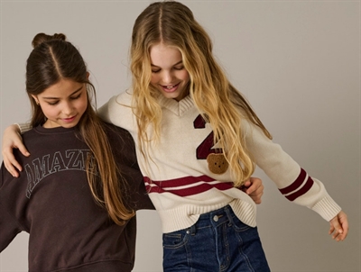 Pige iklædt KIDS ONLY striktrøje birch med bjørnebadge og striber til piger