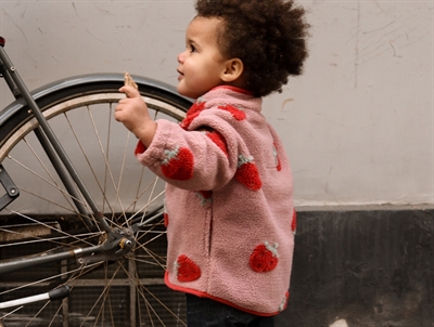 Pige iklædt Mikk-line teddy jakke strawberry aop med jordbærprint