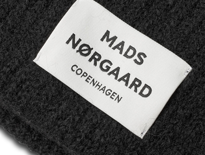 Nærbillede af logolabel på sort Anju hue fra Mads Nørgaard
