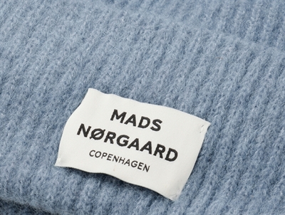 Nærbillede af Mads Nørgaard logo på lyseblå hue