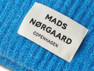 Nærbillede af Mads Nørgaard hue i malibu blue med logomærke