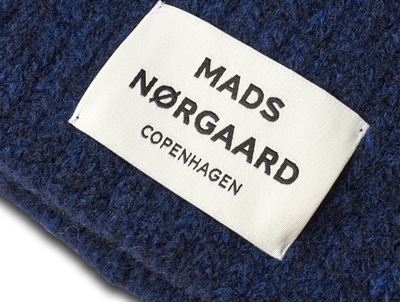 Nærbillede af Nørgaard hue i mørkeblå med logo