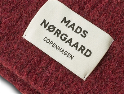 Close-up af Mads Nørgaard hue i winery med logo