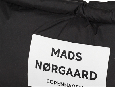 Nærbillede af Mads Nørgaard logo på sort puffertaske