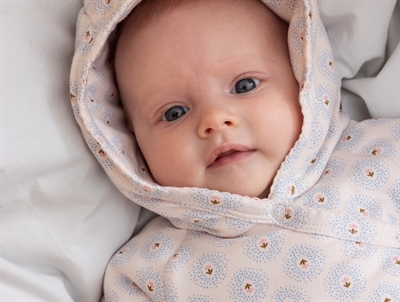 Baby med hætte iført MarMar køredragt i farven little tulip