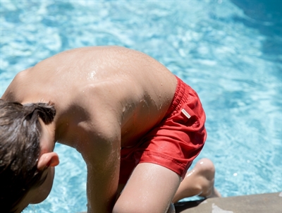 Barn iklædt MarMar Swiggo badeshorts i rød nuance