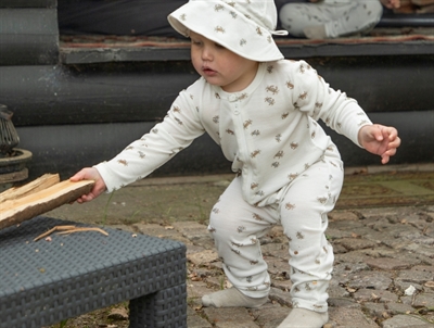 Barn iklædt Joha heldragt i råhvid nuance med krabbeprint i uld og silke