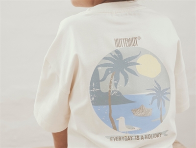 Dreng iklædt Huttelihut t-shirt i råhvid med brystlomme og print på ryggen