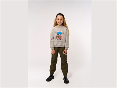 Pige iført grå sweatshirt fra THE NEW med teddy print