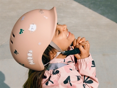 Pige med Liewood Milly cykelhjelm i rosa med mood klistermærker på